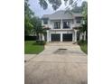 Two-story home with private garages and balconies with black railings at 2011 E Esther St, Orlando, FL 32806