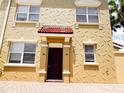 Detailed exterior showcases unique architectural textures and a striking red-tiled entrance canopy at 2404 Bella Vista Dr, Davenport, FL 33897