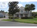 Inviting two-story home with a covered entrance, lush landscaping, a well-kept lawn, and a charming curb appeal at 2543 Chapala Dr, Kissimmee, FL 34746