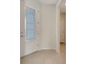 Bright foyer featuring a decorative glass front door, neutral walls, and ceramic tile flooring throughout at 2578 Cliff Way, St Cloud, FL 34771