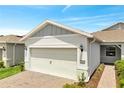 Exterior view showcasing a well-maintained home with a two-car garage, brick driveway, and landscaped walkway at 2578 Cliff Way, St Cloud, FL 34771