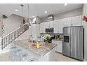 Modern kitchen with granite countertops, stainless steel appliances, and stylish pendant lighting at 2630 Sunrise Shores Dr, Kissimmee, FL 34747