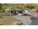 Charming single-story home featuring a manicured lawn and a welcoming driveway, surrounded by mature trees at 2829 Lake Griffin Rd, Lady Lake, FL 32159