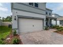 View of the two-car garage and brick paver driveway of this charming two-story home at 4007 Meandering Bay Dr, Apopka, FL 32712