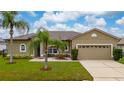 Attractive one-story home with well-manicured lawn and front yard landscaping, including mature palms at 55 Altera Ct, Kissimmee, FL 34758