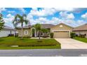 Well-maintained one-story home with neat landscaping, including palm trees, and a two-car attached garage at 55 Altera Ct, Kissimmee, FL 34758