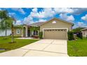 Inviting one-story home featuring a two-car garage and a well-maintained lawn, creating an attractive facade at 55 Altera Ct, Kissimmee, FL 34758