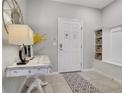 Welcoming foyer featuring a decorative table with a lamp and a built-in storage bench with woven baskets at 720 Gardenia Ln, Davenport, FL 33897