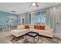 Spacious living room with a large white sectional sofa, stylish rug, and access to outdoor area at 720 Gardenia Ln, Davenport, FL 33897