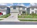 Beautiful two-story home with a manicured lawn, a two-car garage, solar panels, and inviting curb appeal at 7639 Agrigento St, Clermont, FL 34714