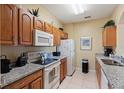 Well-lit kitchen with granite countertops, wooden cabinets, and modern appliances at 7660 Comrow St # 203, Kissimmee, FL 34747