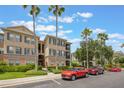 Condo complex with palm trees, well-kept landscaping, and dedicated parking at 8168 Boat Hook Loop # 201/718, Windermere, FL 34786