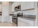 Bright kitchen features white cabinetry, modern appliances, and quartz countertops at 865 Citrus Reserve Blvd, Davenport, FL 33837