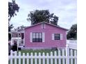 Quaint pink bungalow with white trim, a covered porch, and a charming picket fence at 1038 26Th St, Orlando, FL 32805