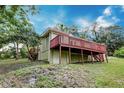 Back of home with a large deck, overlooking a sloping lawn at 1335 E 3Rd Ave, Mount Dora, FL 32757