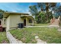 Quaint single-story home with a covered entryway and lush greenery surrounding the property at 1335 E 3Rd Ave, Mount Dora, FL 32757