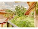 Scenic view from the balcony featuring lush greenery, palm trees, and partial building rooftops at 150 Wax Myrtle Woods Ct # 3D, Deltona, FL 32725