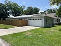 The backyard features a spacious driveway and a two-car garage, perfect for parking and storage at 1501 Delaware Ave, St Cloud, FL 34769
