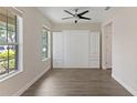 Bedroom with grey wood floors, built-in cabinets and drawers, a ceiling fan, and two windows at 15229 Evergreen Oak Loop, Winter Garden, FL 34787