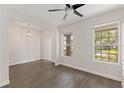 Bright living room with gray wood floors, two large windows for natural light, and recessed lighting at 15229 Evergreen Oak Loop, Winter Garden, FL 34787