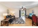 Comfortable living room with hardwood floors, ceiling fan, and sliding glass doors to the exterior at 1591 Pendleton St, Deltona, FL 32725