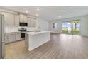 A bright, spacious kitchen with stainless steel appliances, center island, and sliding door to the backyard at 1689 Greenleaf Woods Cv, Oviedo, FL 32765