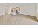 Open floor plan features a modern kitchen flowing into a bright and airy living area with hardwood floors at 1689 Greenleaf Woods Cv, Oviedo, FL 32765