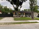 Charming single story home with a lawn, mature trees, dark shutters, and outdoor seating area on the front porch at 170 N Fairfax Ave, Winter Springs, FL 32708