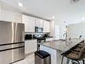 Modern kitchen featuring stainless steel appliances, granite countertops, and a breakfast bar at 29783 Anahid Dr, Leesburg, FL 34748