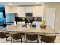 Modern kitchen featuring a large granite island with seating and stainless steel appliances at 29783 Anahid Dr, Leesburg, FL 34748