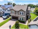 Aerial view of a two-story home with a brick driveway and mature trees at 3172 Jade Tree Pt, Oviedo, FL 32765