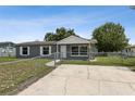 Single-story home with a gray exterior and white trim, plus a chain-link fence and concrete driveway at 325 Little Aspen Ct, Ocoee, FL 34761