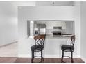 A view of the kitchen with stainless steel appliances and white cabinets, as viewed from the breakfast bar at 399 Lake Daisy Dr, Winter Haven, FL 33884