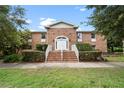 Well-maintained brick building featuring covered entryway, manicured shrubs and greenery at 4312 Lake Underhill Rd # 19-B, Orlando, FL 32803