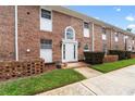 Charming brick townhome featuring a white front door with an arched window and manicured lawn at 4312 Lake Underhill Rd # 19-B, Orlando, FL 32803