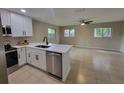 Open kitchen with stainless steel appliances overlooking a naturally lit living area at 4883 Cherokee Rose Dr, Orlando, FL 32808