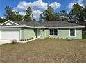Lovely single-story home featuring a two-car garage, a welcoming front door, and a well-maintained lawn at 51 Fir Dr, Ocala, FL 34472