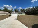 Inviting single-Gathering home featuring a spacious front yard and a long driveway, perfect for families at 51 Fir Dr, Ocala, FL 34472