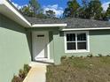 Welcoming entryway featuring a white front door with glass accents and manicured landscaping at 51 Fir Dr, Ocala, FL 34472