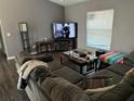 Cozy living room with gray walls, large sectional sofa, and entertainment center with a TV at 7047 Sw 131St Loop, Ocala, FL 34473