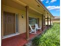 Inviting front porch with rocking chairs, and stately columns with decorative trim at 7852 Broken Arrow Trl, Winter Park, FL 32792