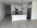 Modern kitchen with white cabinets, stainless steel appliances, and large island at 798 Kapi Dr, Groveland, FL 34736