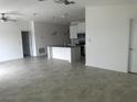 Spacious living area with neutral tones, ceiling fan, and adjacent kitchen at 798 Kapi Dr, Groveland, FL 34736
