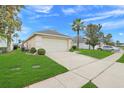 Exterior view with a spacious driveway, green lawn, and partial view of a palm tree at 915 Lockbreeze Dr, Davenport, FL 33897