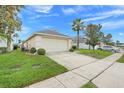 Exterior angle of home and driveway showcasing landscaping and side entry garage in a well-maintained yard at 915 Lockbreeze Dr, Davenport, FL 33897