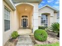 Inviting covered entryway featuring a decorative wreath on the front door, offering a warm welcome at 915 Lockbreeze Dr, Davenport, FL 33897