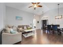 Open-concept living room boasts wood floors, high ceilings, and ample natural light, perfect for entertaining at 915 Lockbreeze Dr, Davenport, FL 33897