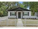 Charming bungalow with a white picket fence, dark shutters and a freshly painted exterior at 1002 Cypress Ave, Sanford, FL 32771