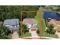 Aerial view showcases home's position in a lush, green landscape with a tranquil pond nearby at 1016 Fountain Coin Loop, Orlando, FL 32828
