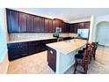 Modern kitchen featuring granite countertops, stainless steel appliances, and rich wood cabinetry at 1016 Fountain Coin Loop, Orlando, FL 32828